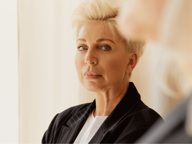 A rich woman staring at someone with a disgusted look.