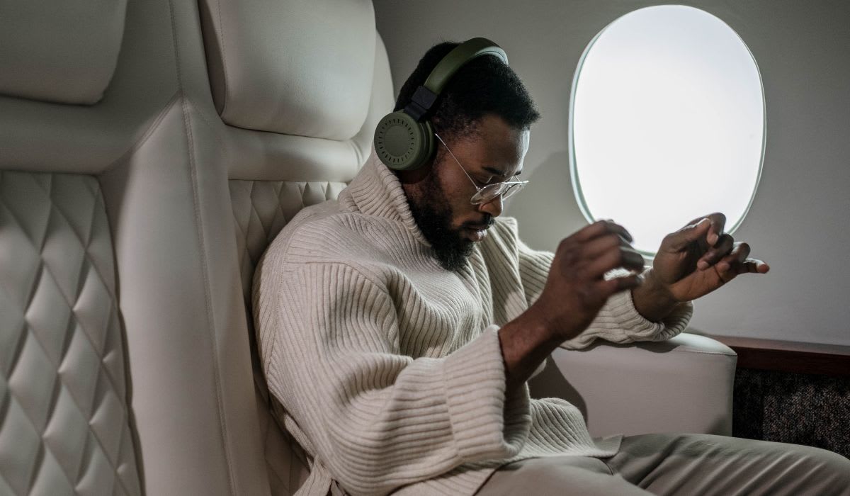 Man enjoying music wearing a pair of headphones in a flight. (Representative Image Source: Pexels | Cottonbro Studio)
