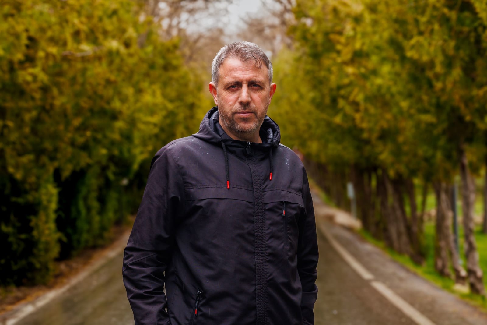 A man looks sternly while walking on street.