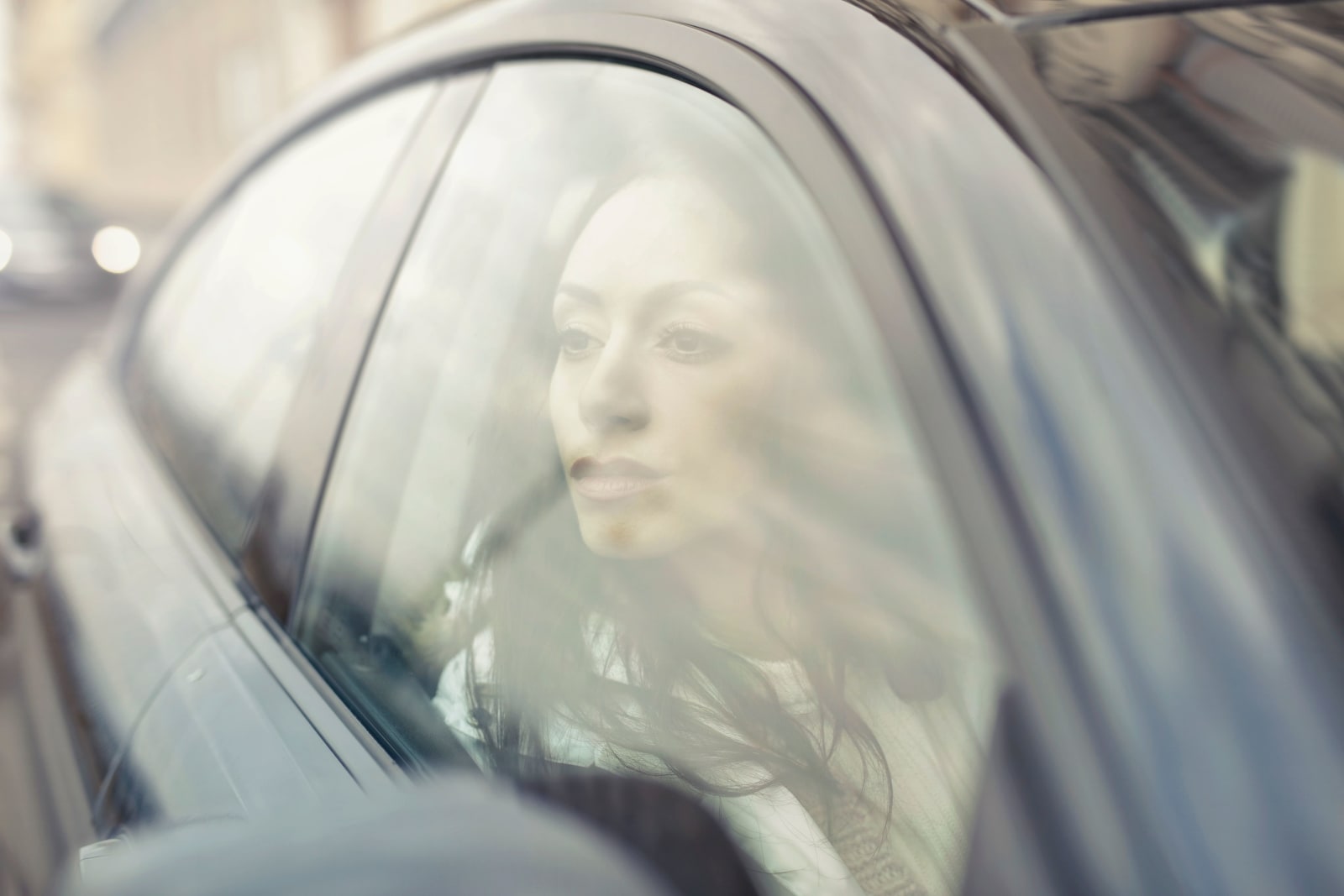 A woman driving, looks at someone angrily.