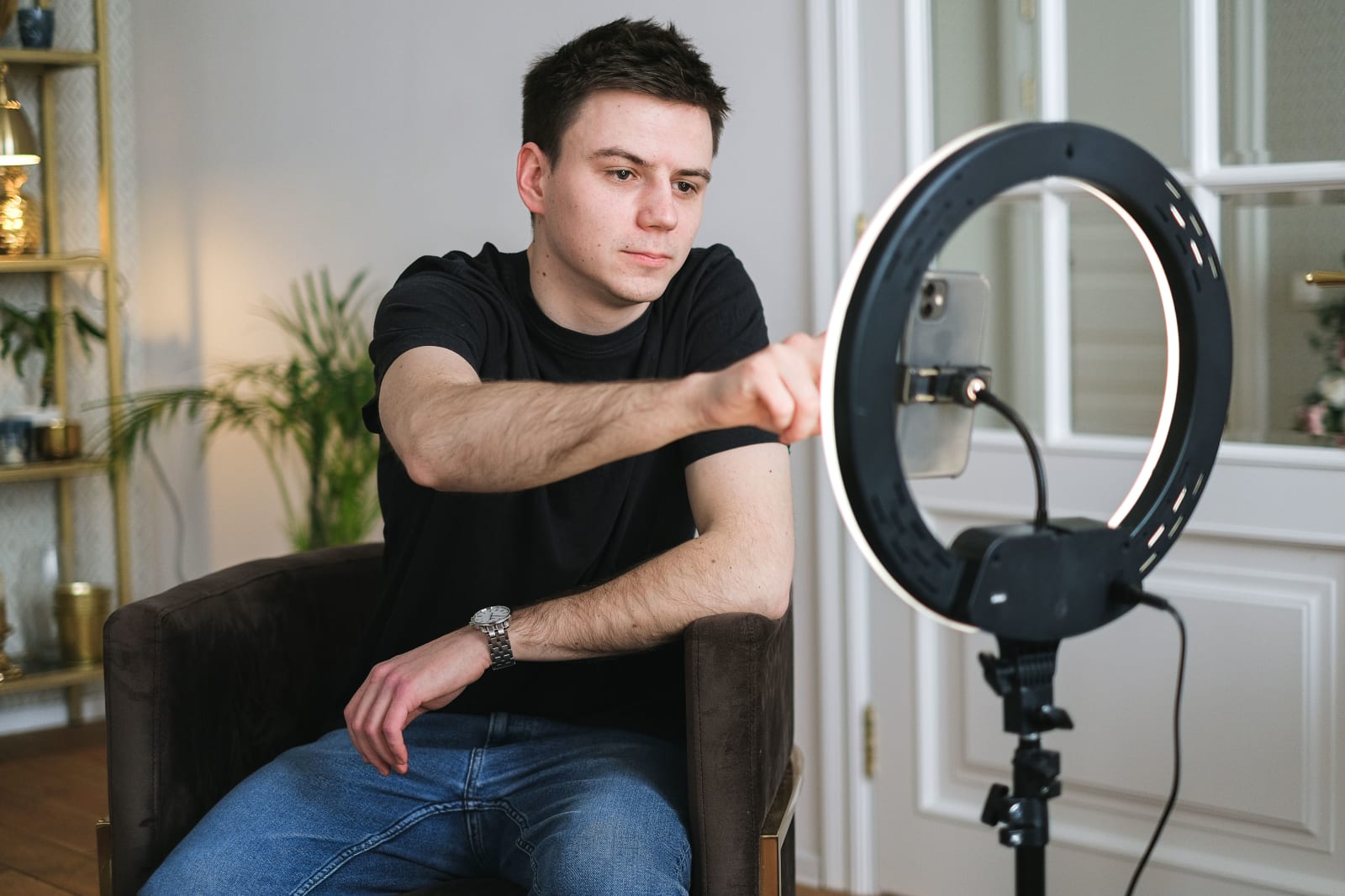A male content creator is recording something on his phone.
