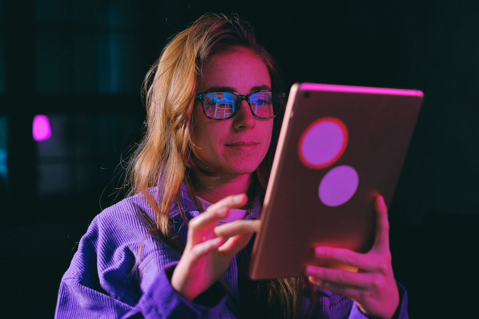 A woman looks at her iPad intently.