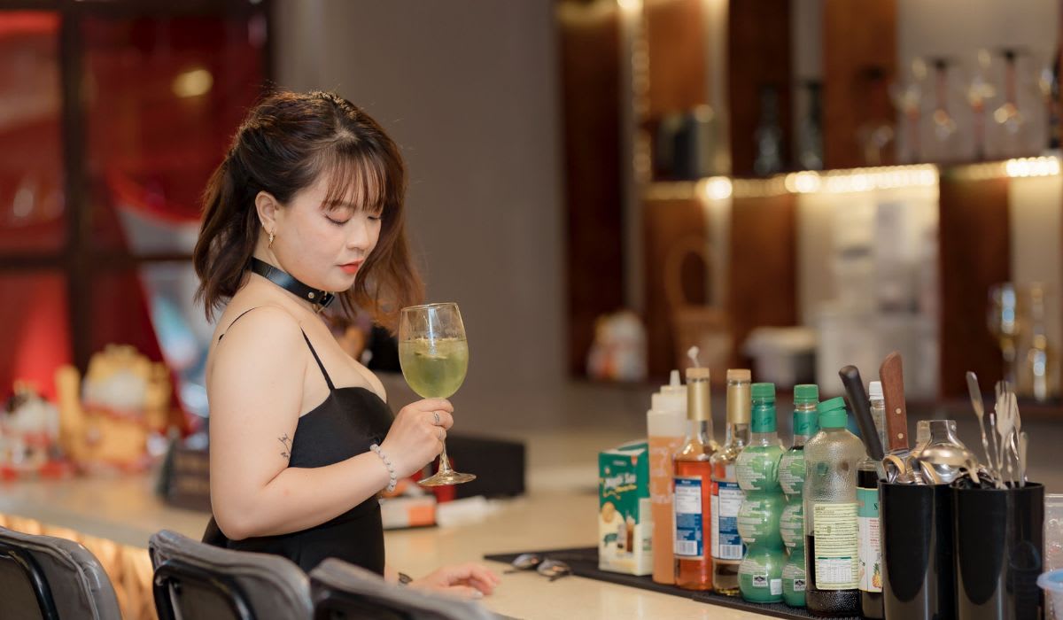 Stylish woman in black dress enjoying a cocktail at a modern bar. (Representative Image Source: Pexels |&nbsp;Nguyễn Tiến Thịnh)
