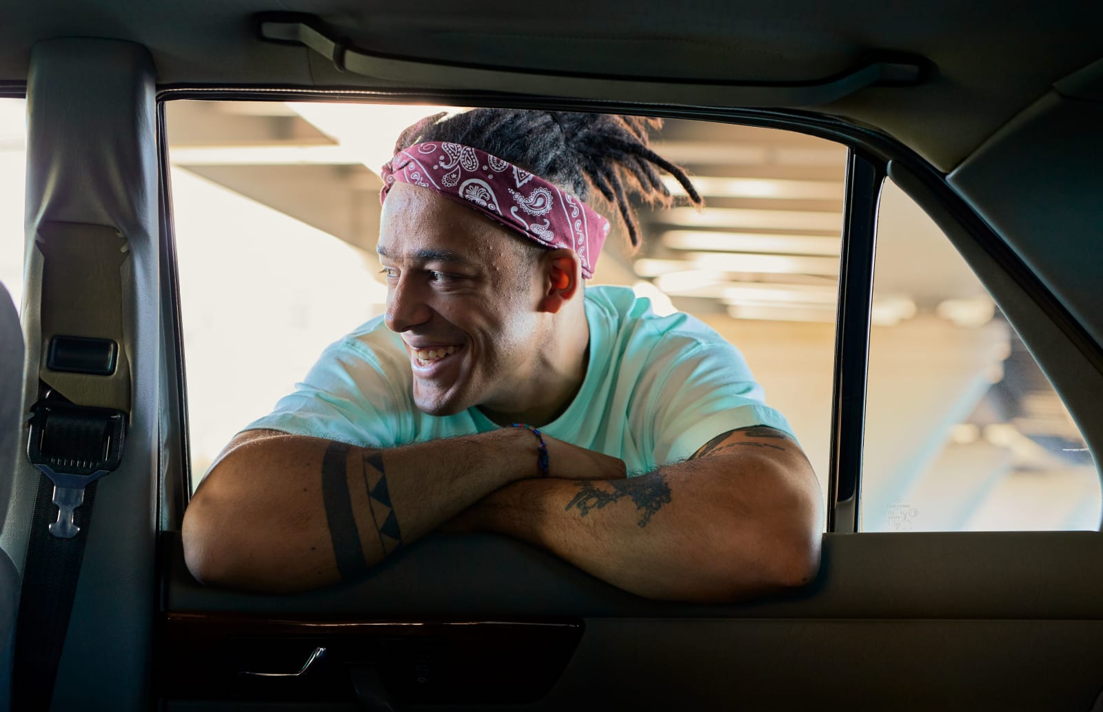 A man laughs as he gets into a car.