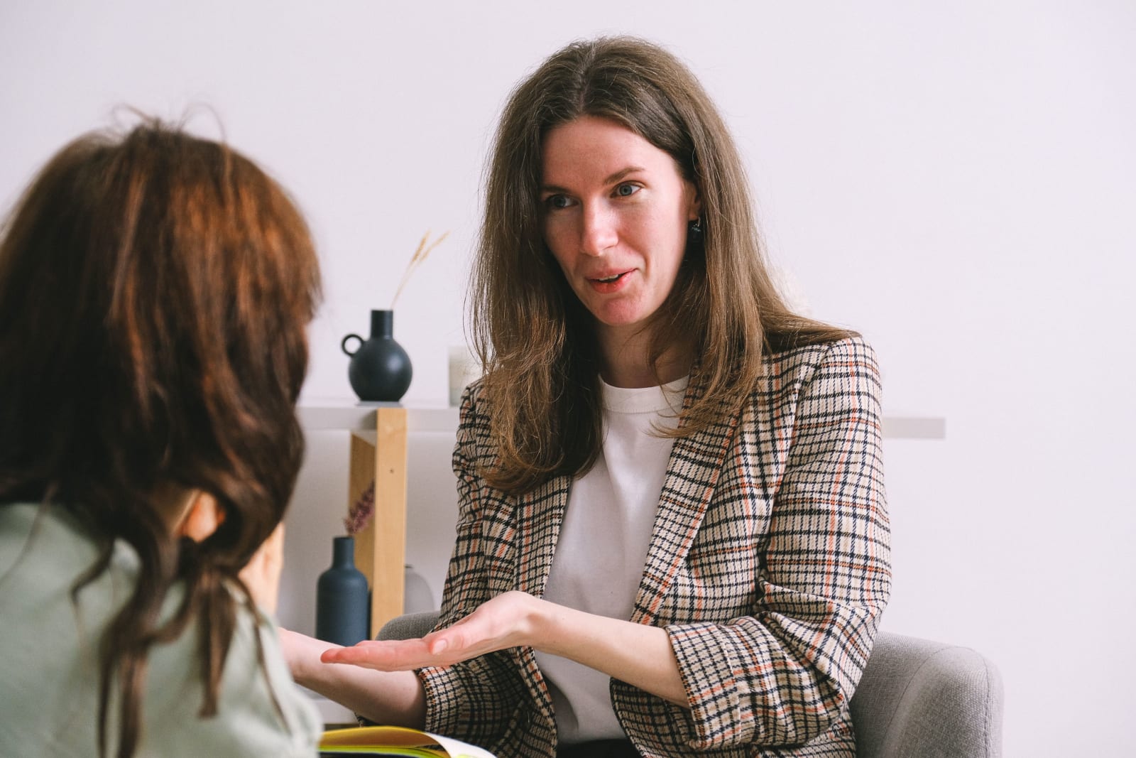 A woman is recommending something while speaking with a person.