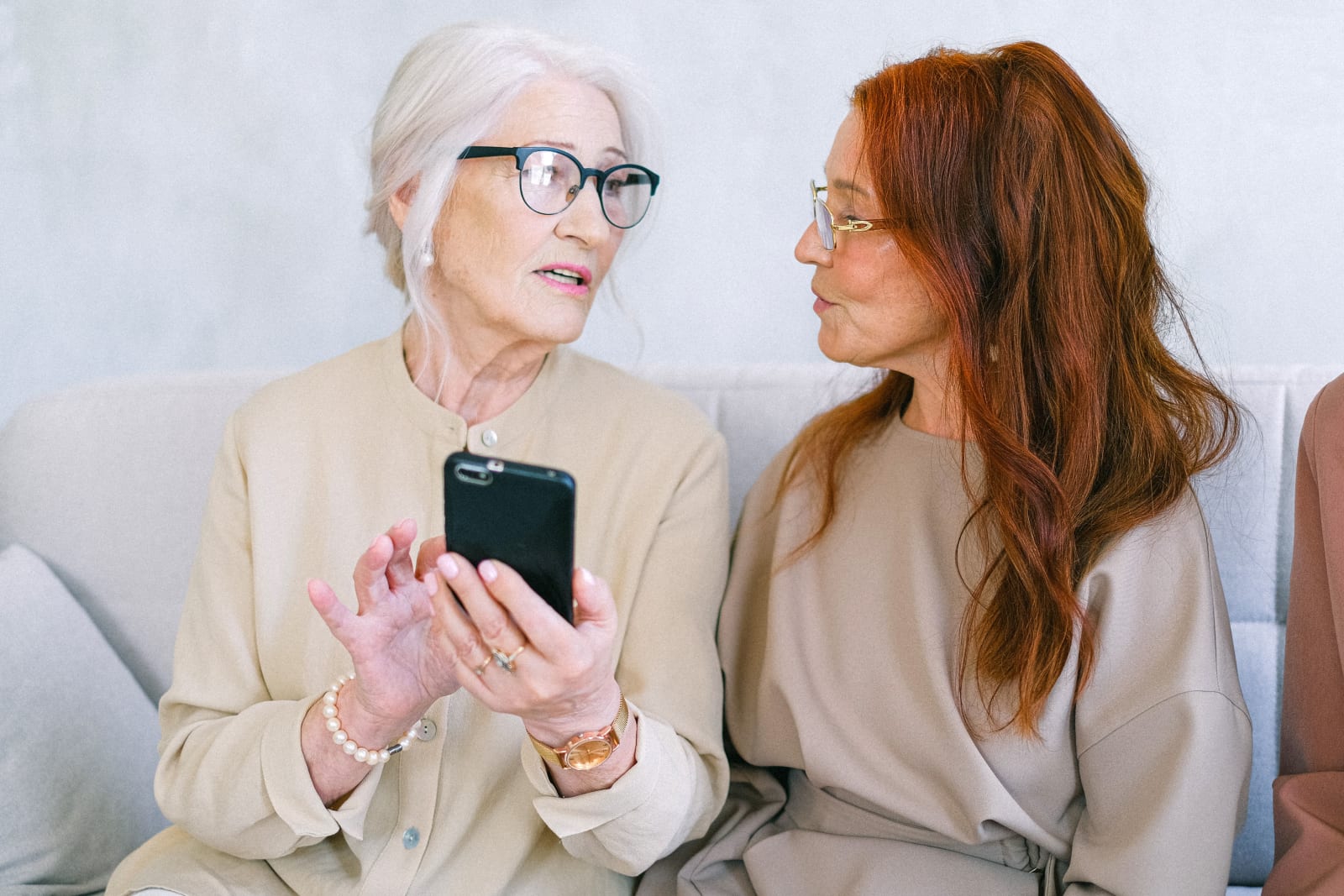 Two elderly woman look at phone disappointely.