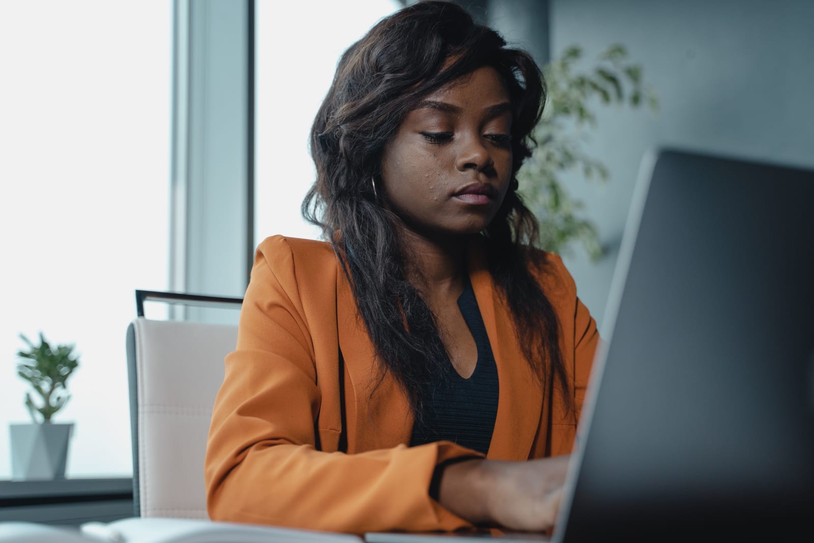 A woman is typing on her laptop.