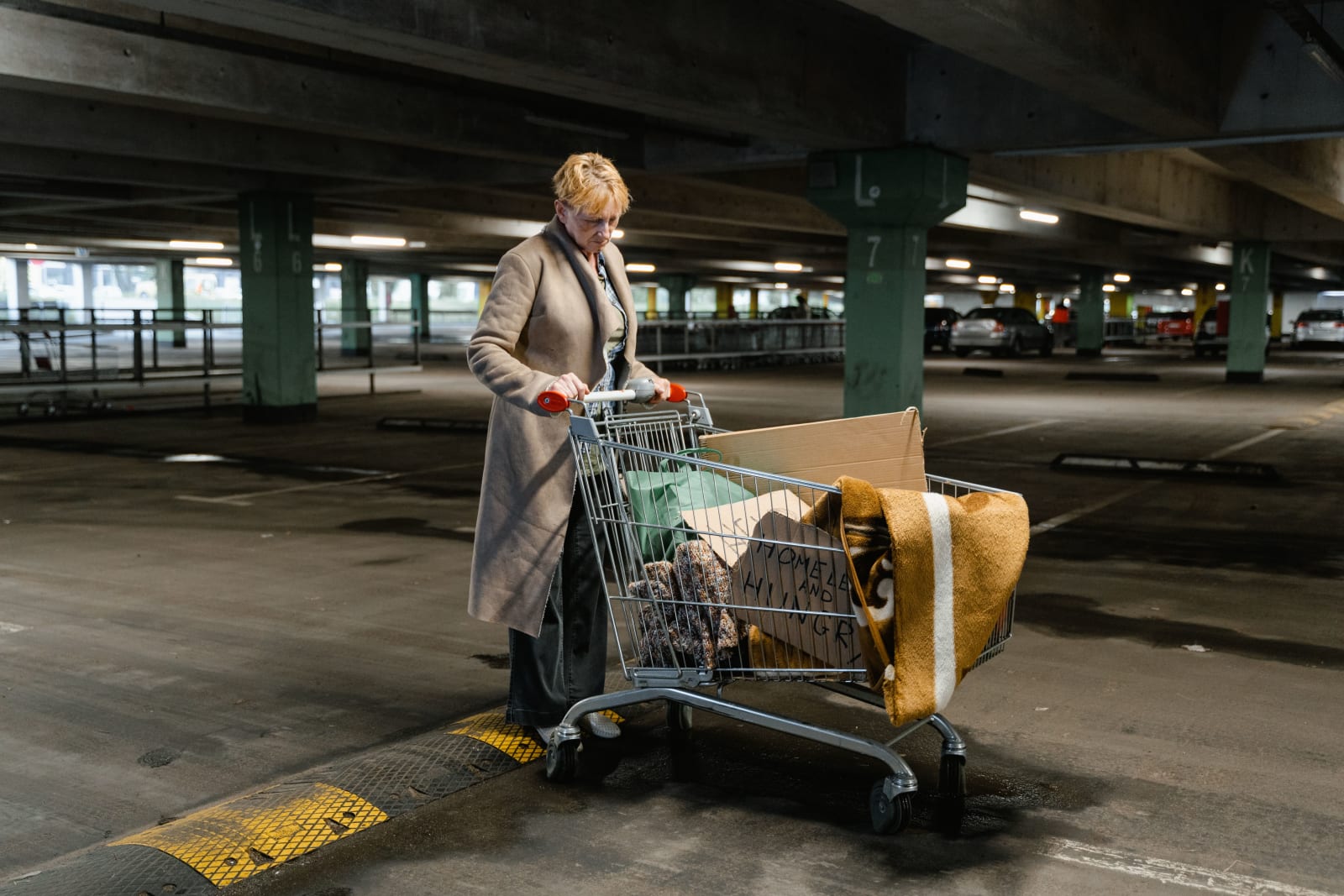 Woman pushing shopping cart in empty parking garage (Representative Image Source: Pexels | MART PRODUCTION)