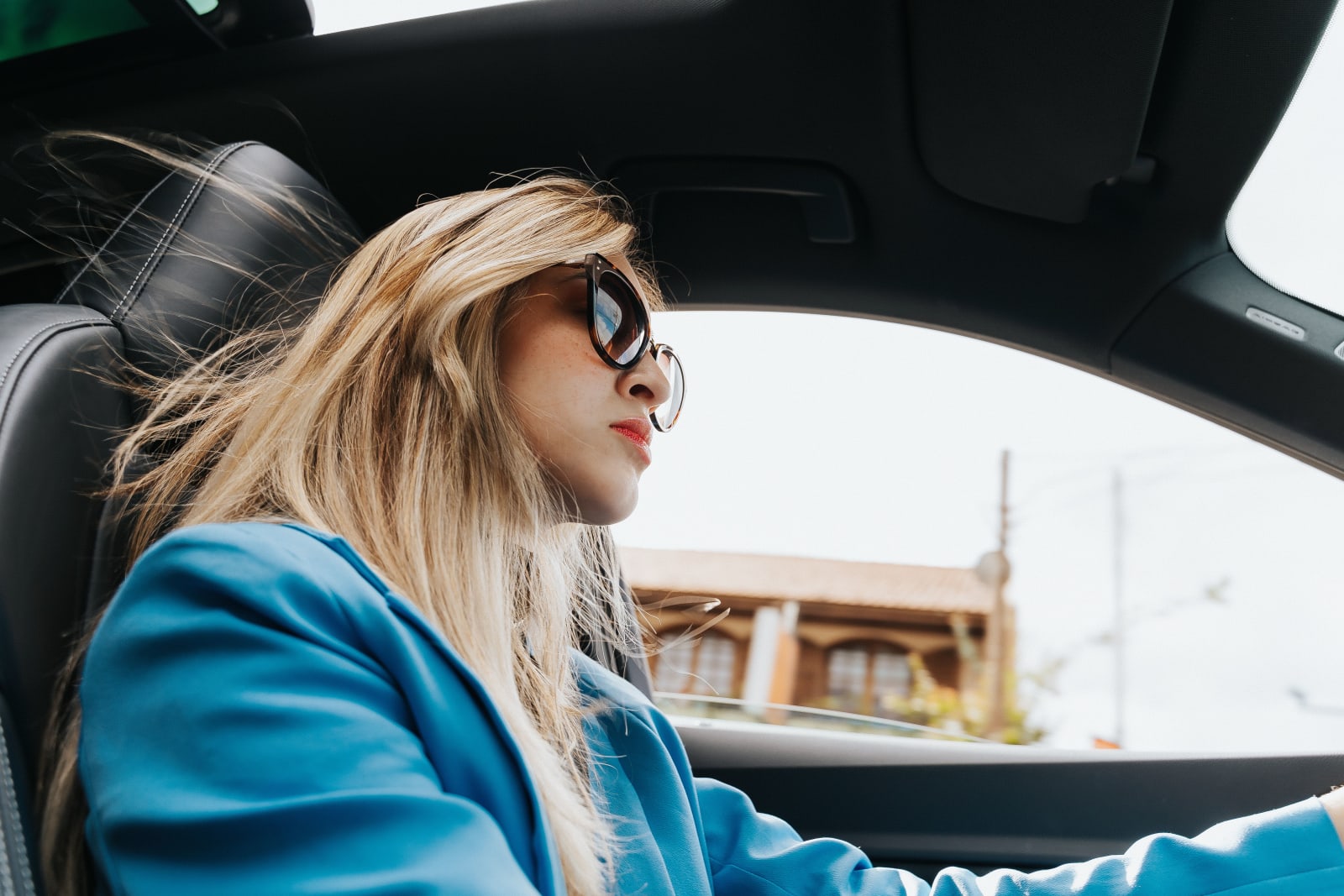 A woman looks suspiciously from her car.
