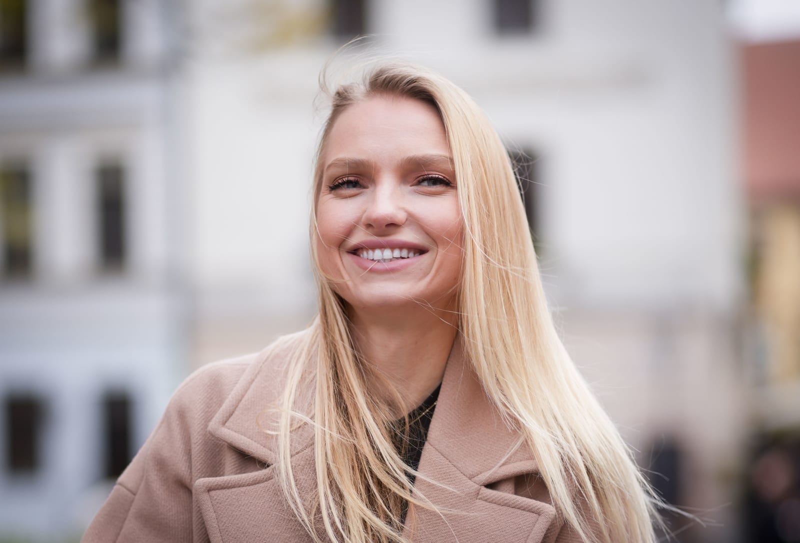 A woman smiles while speaking.