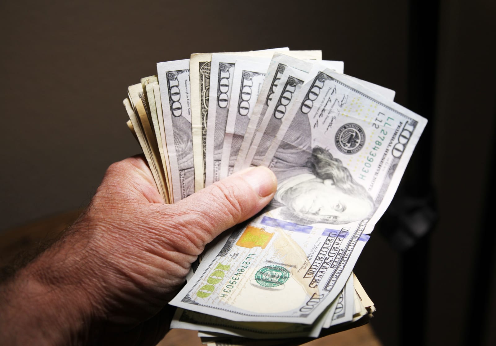 A man holding a stack of cash.