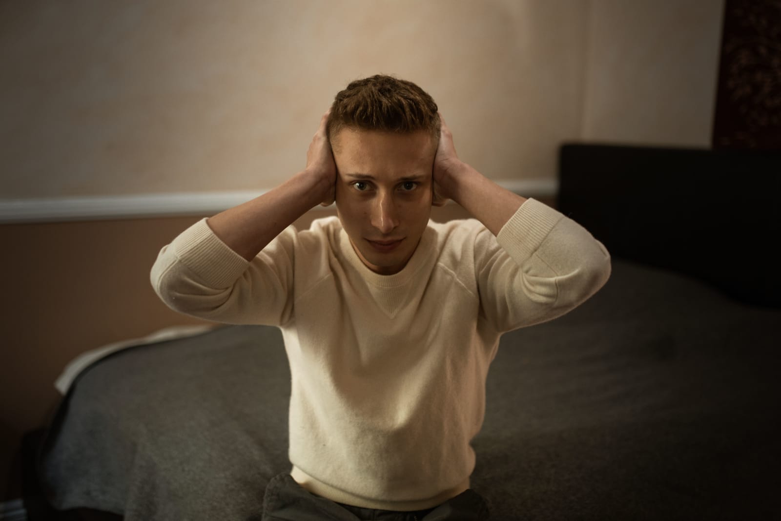 A man covering his ears due to loud music.