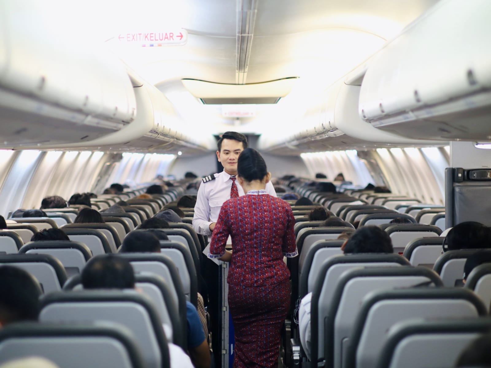 Cabin crew assisting passenger in flight.