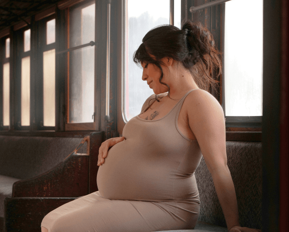 A pregnant woman is touching her belly.
