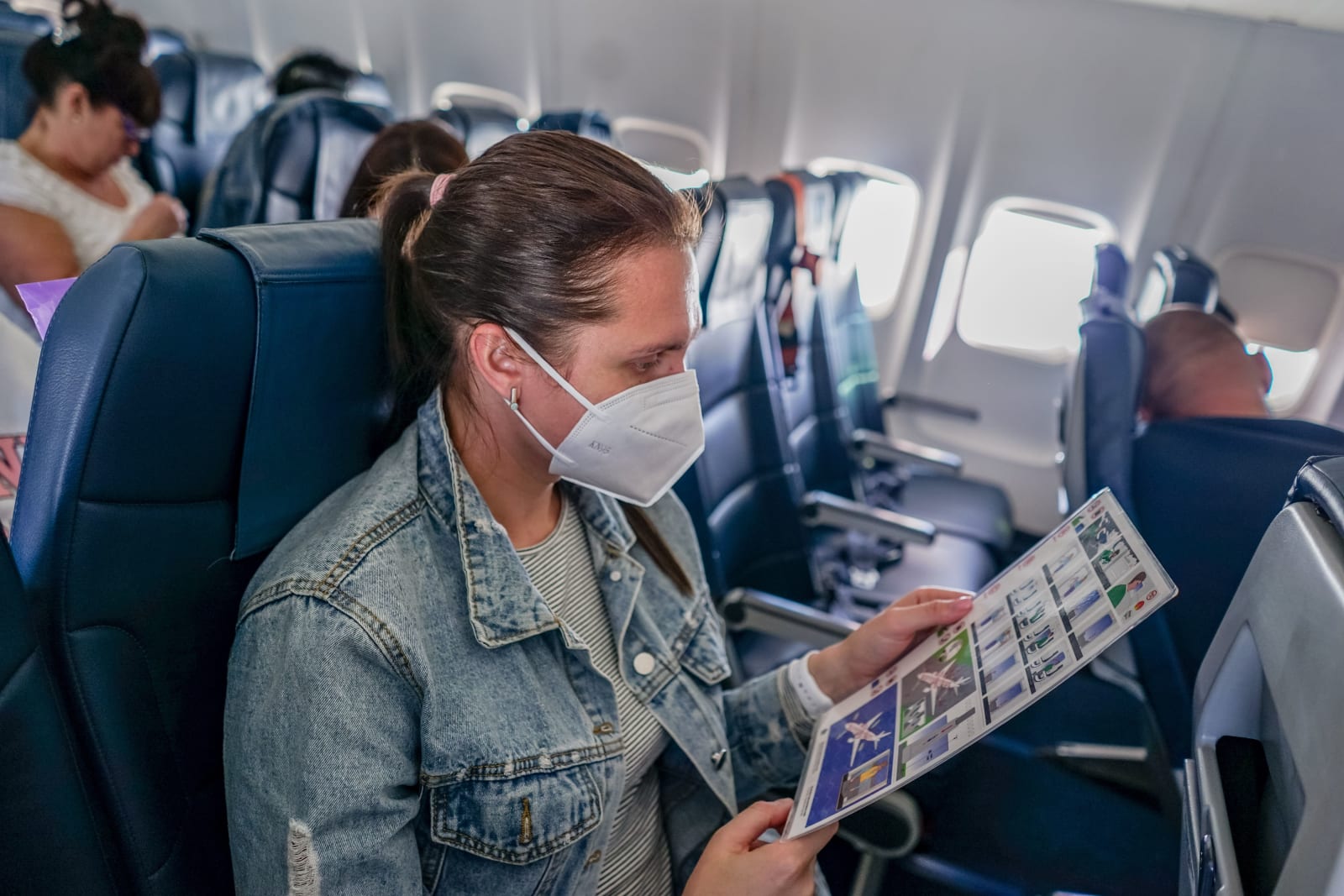 A woman seated in a plane.