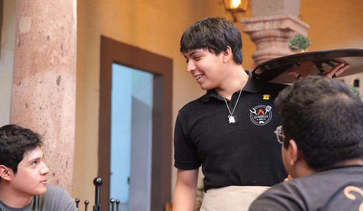 Waiter interacting with customers in a charming Mexican restaurant. (Representative Image Source: Pexels | Allan González)