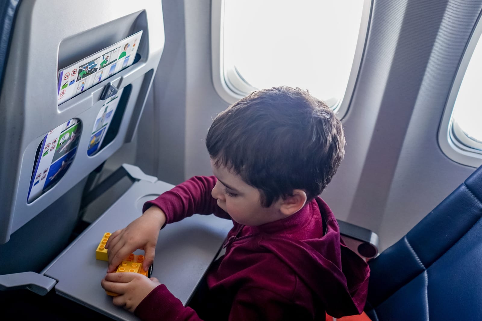 A little boy seated quietly in a plane.