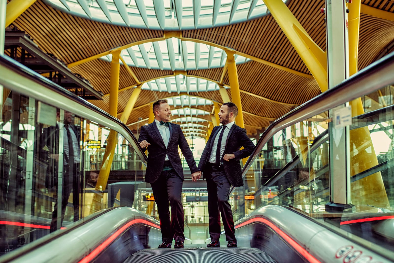 Two men in suits pulling up to an event.