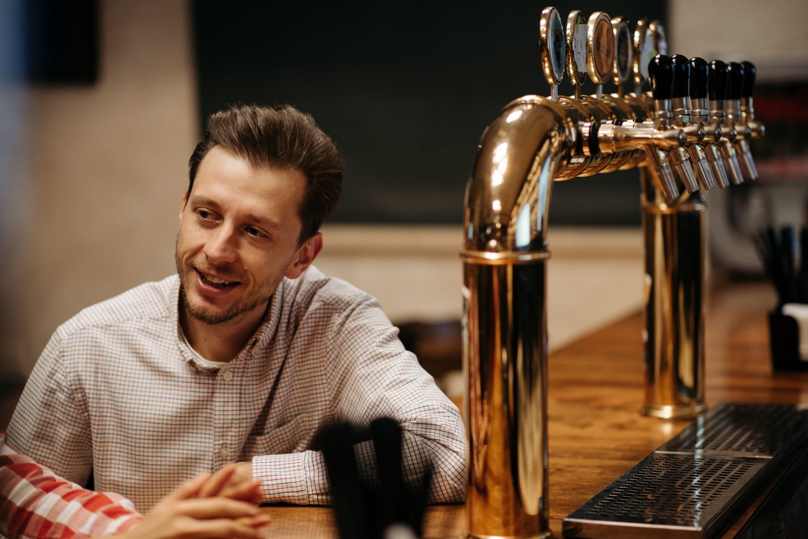 A man talking to someone at a bar.