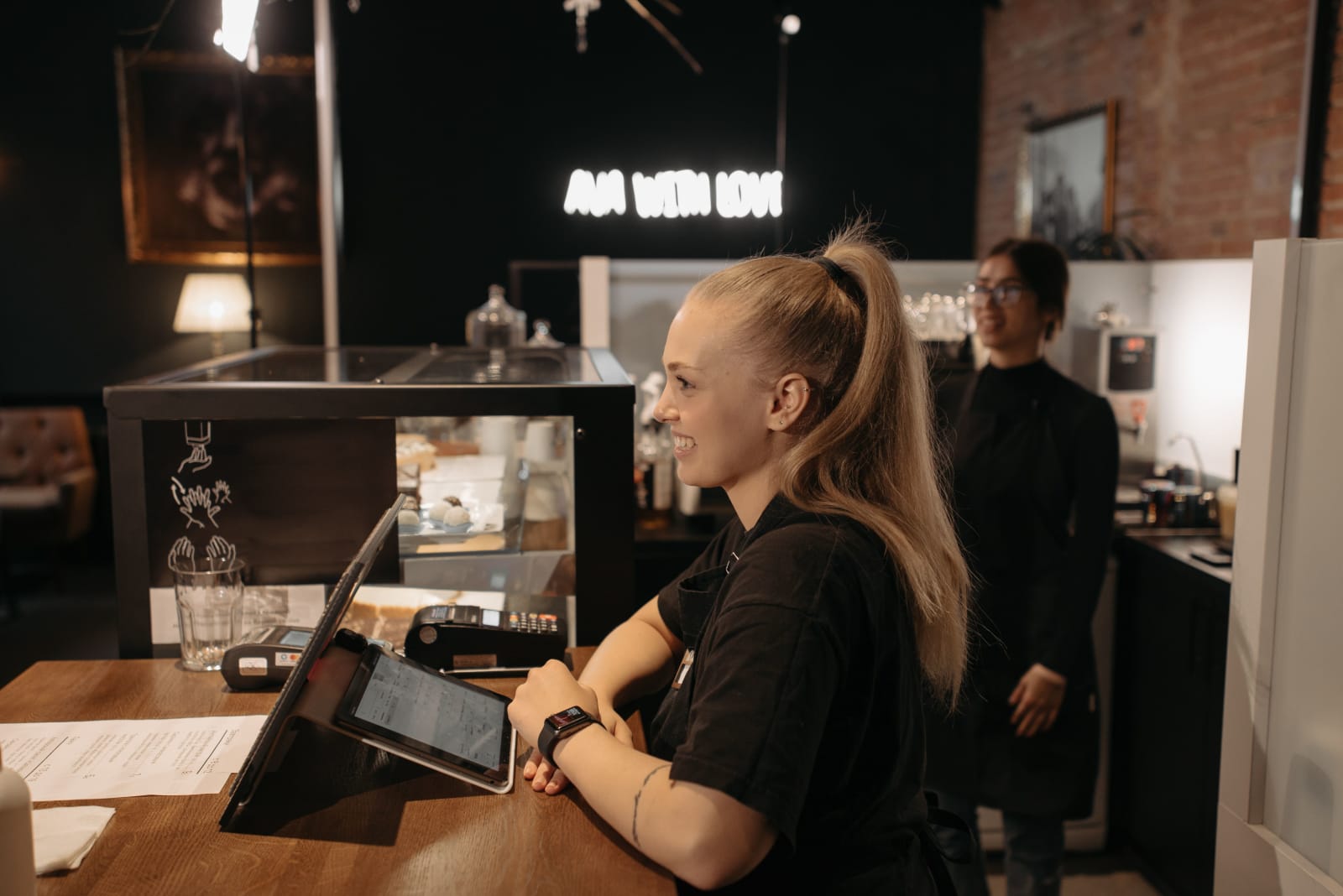 A waitress smiling while speaking to customer.