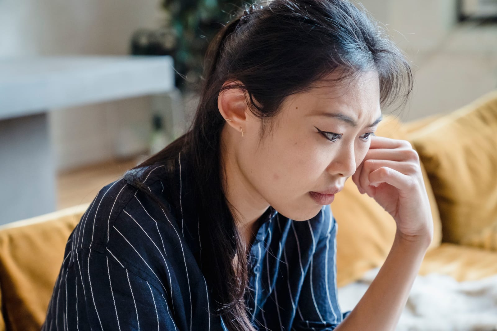 A woman looks tensed and worried.