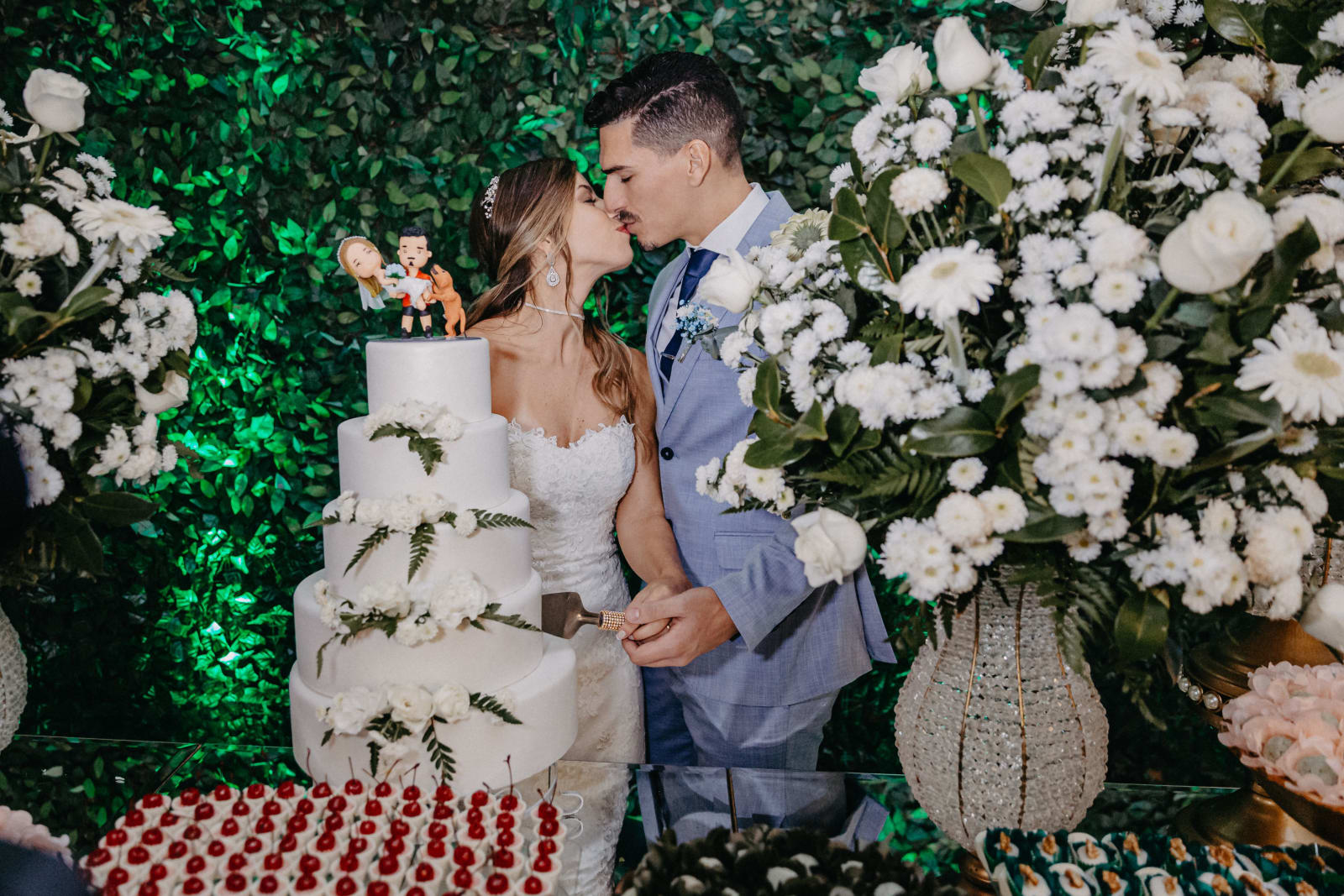 A bridal couple kissing ahead of their cake cutting ceremony.