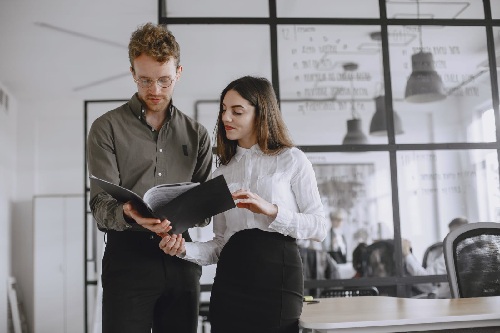 A male and female colleague having a discussion in the office.