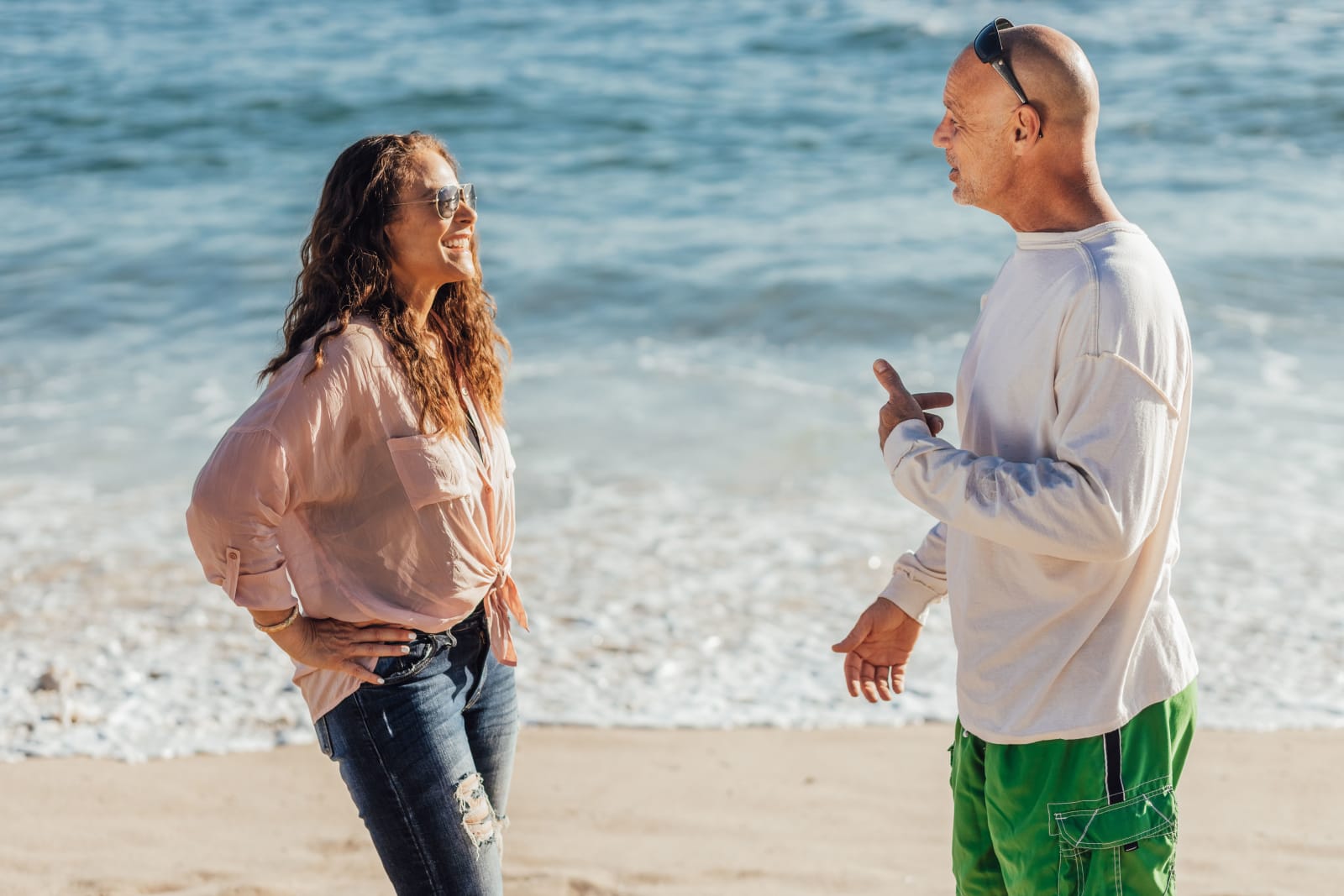 A man talking to a woman on the beach.