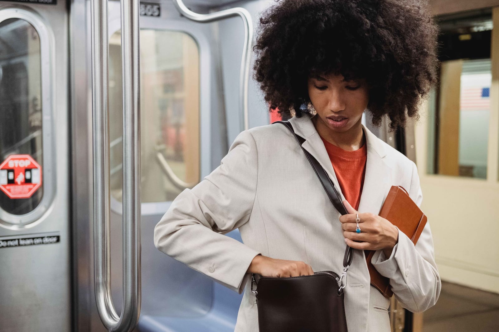 Woman holding a book and adjusting her bag in subway (Representative Image Source: Pexels | Roberto Hund)