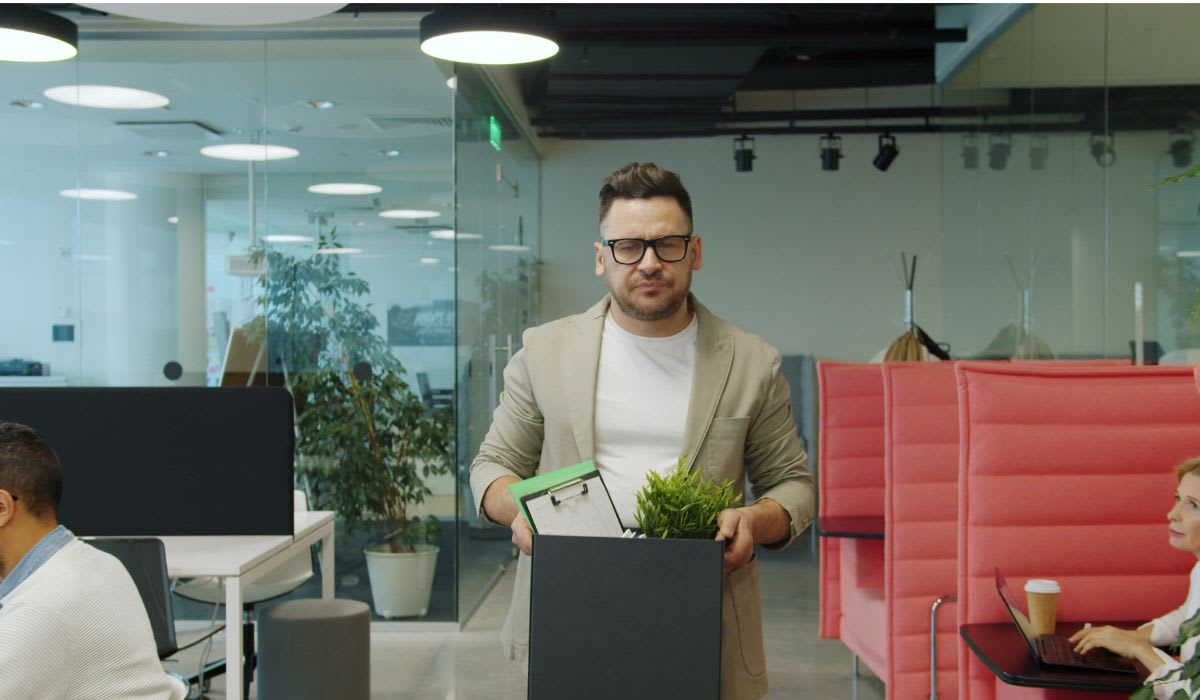 Man carrying a box of belongings, exiting office. (Representative Image Source: Pexels | Vitaly Gariev)