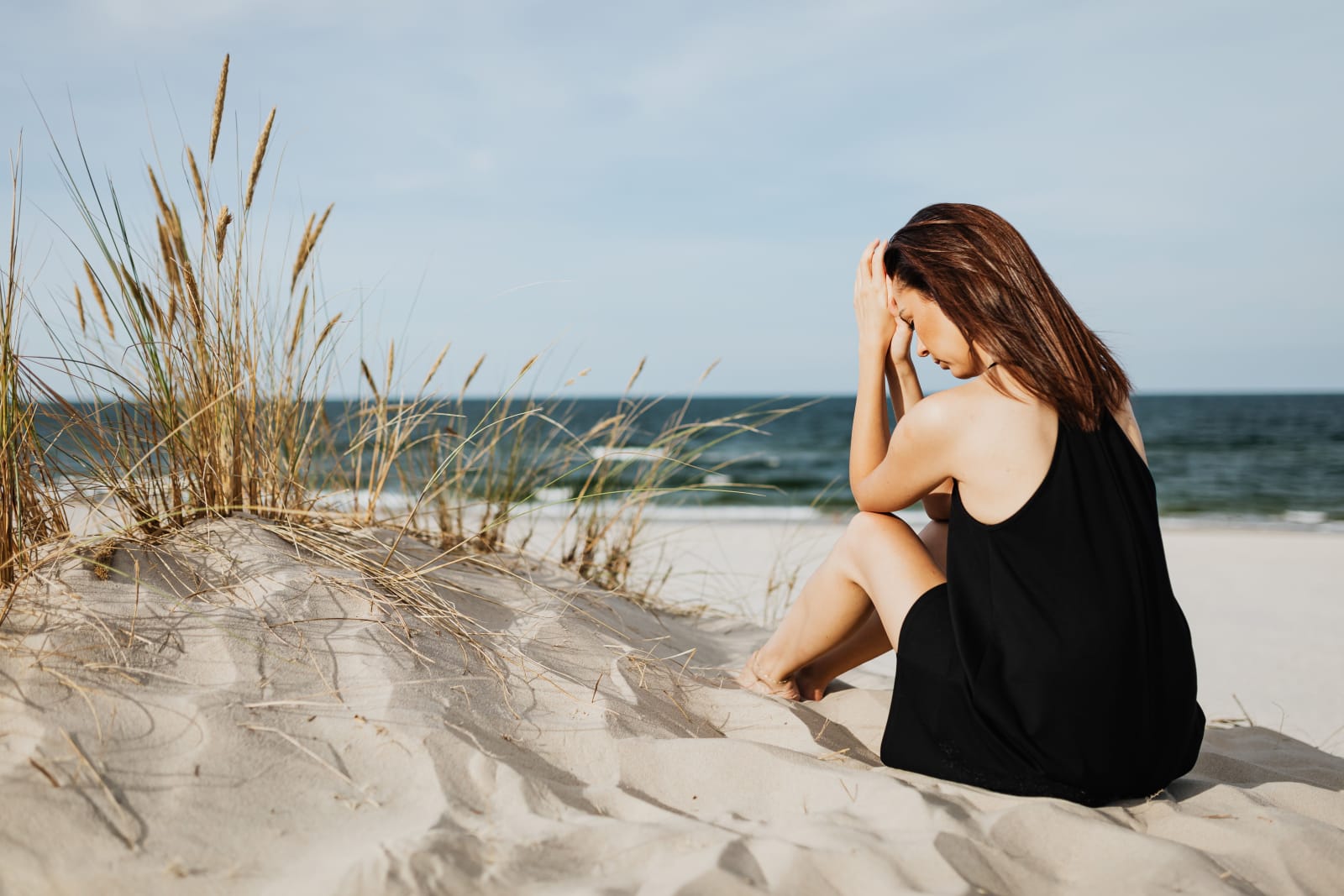 A woman sitting on the beach and pondering deeply. (Representative Image Source: Pexels| K