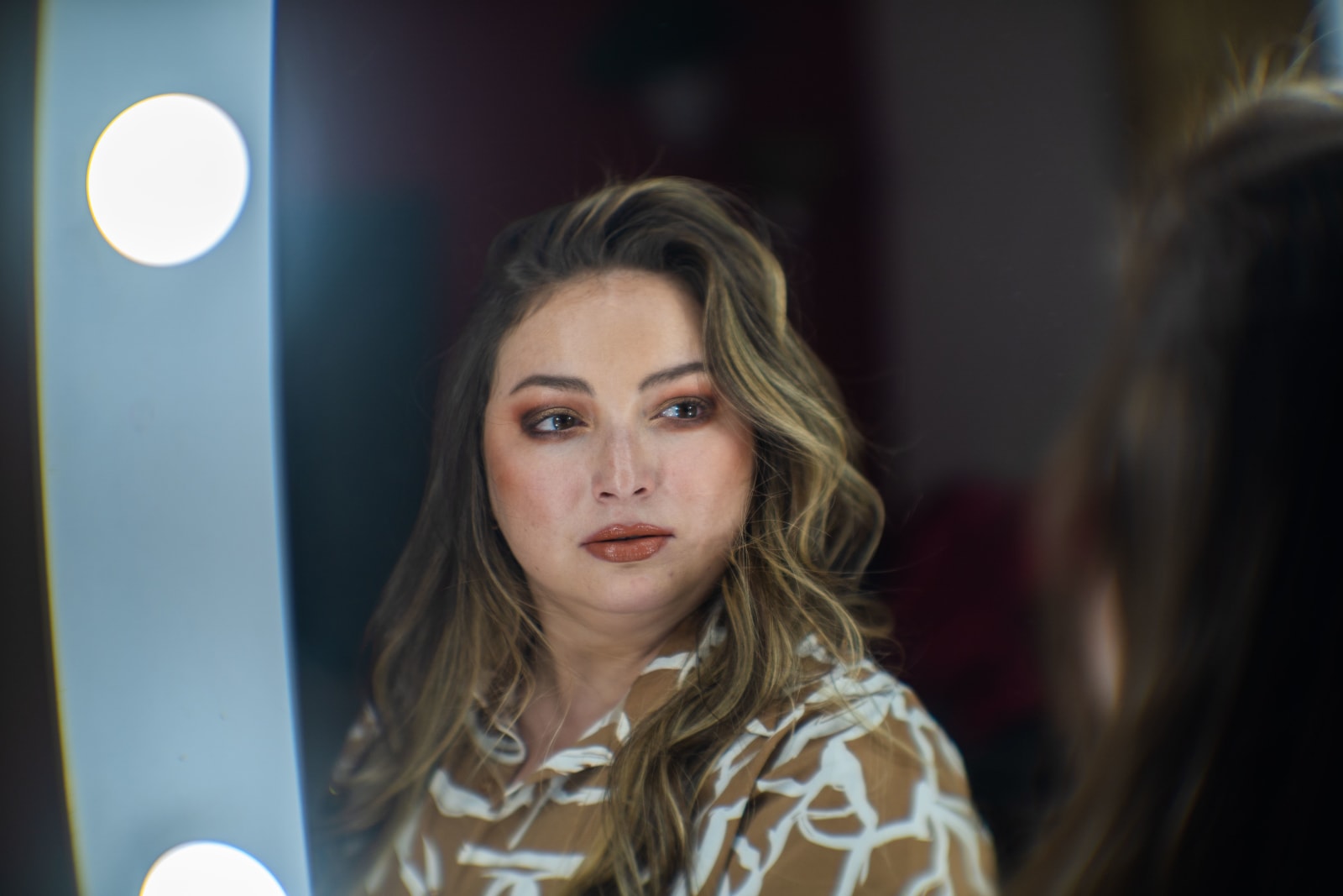 A woman looks at herself in the mirror and feels confident.