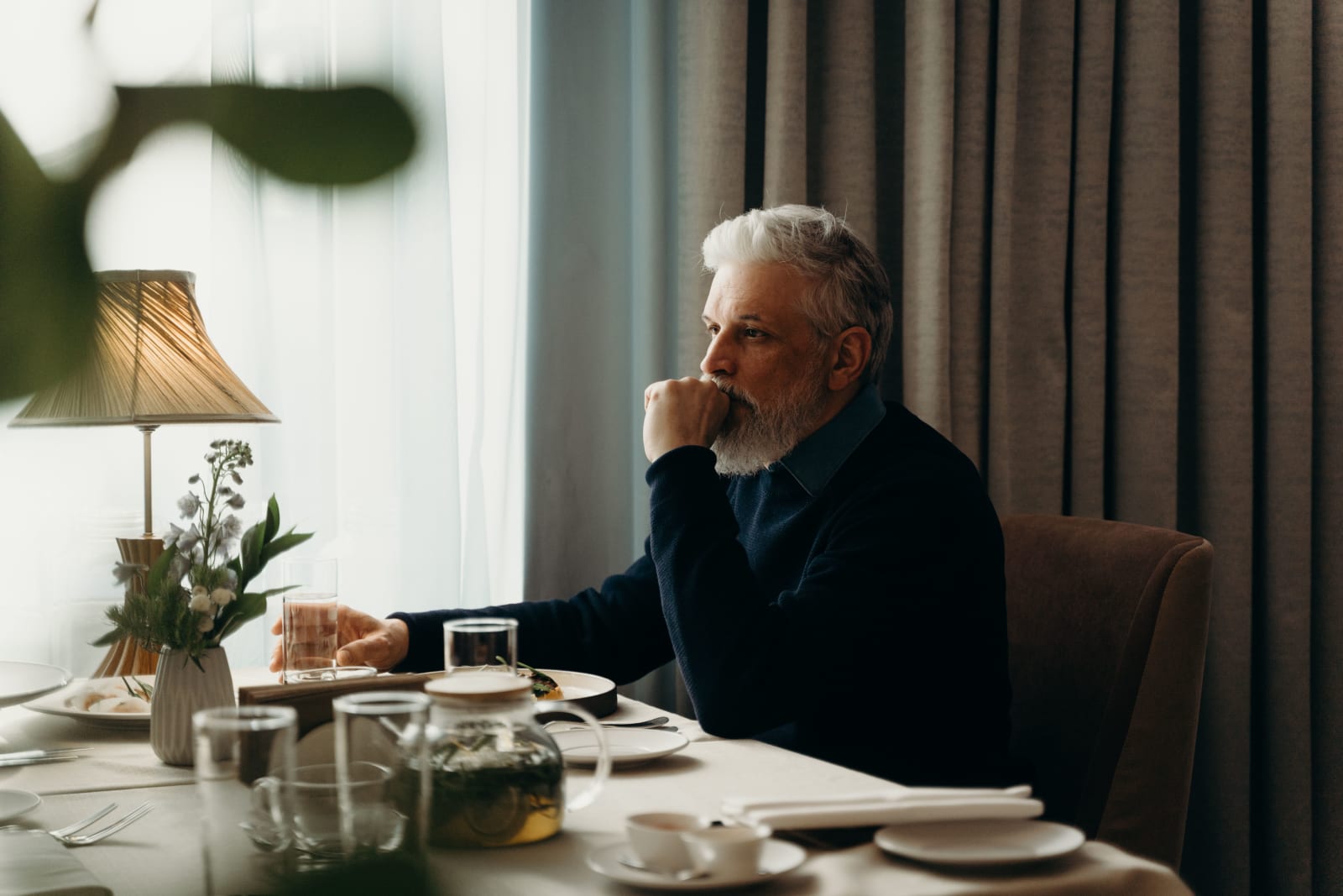 A middle-aged man is pondering sometihng deeply while seated at a restaurant. (Representative Image Source: Pexels| cottonbro studio)