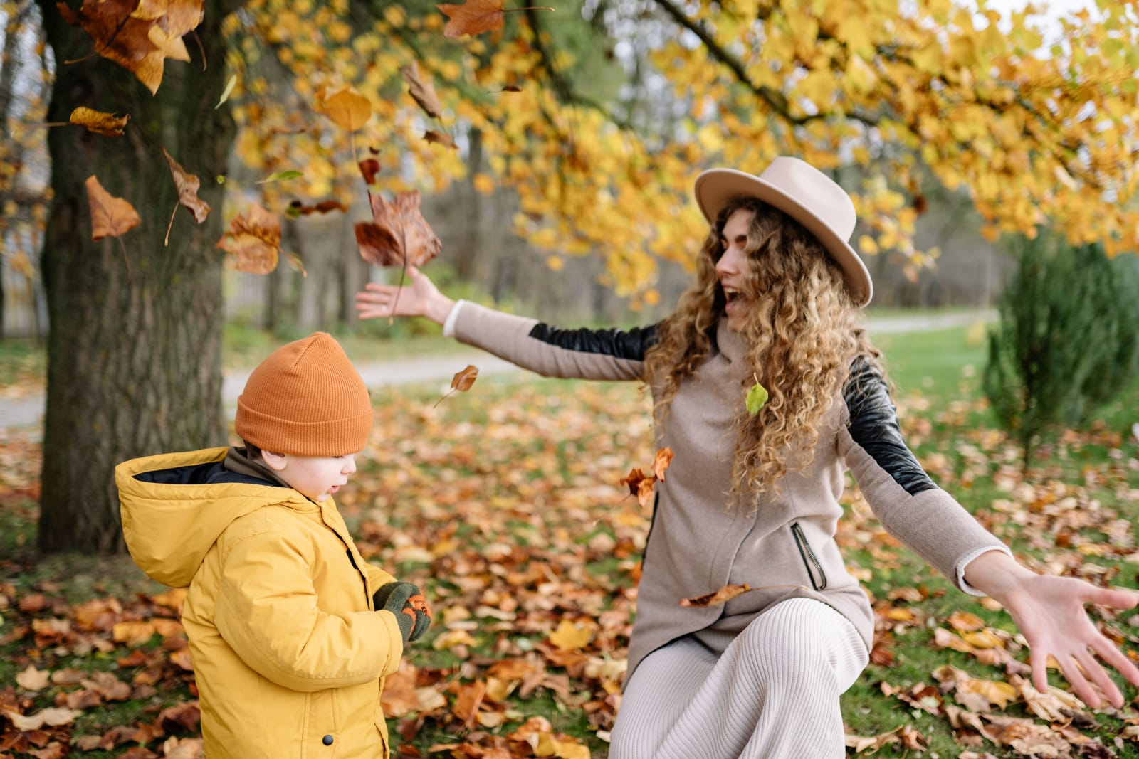 A joyful mother and child playing with autumn leaves in a park. (Representative Image Source: Pexels | Yan Krukau)