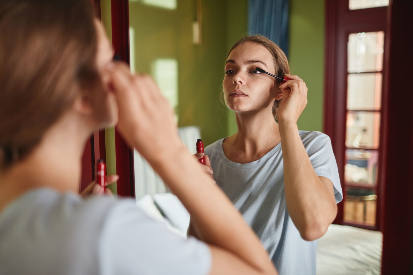 A woman is looking into the mirror and applying makeup. (Representative Image Source: Pexels| Marcus Aurelius)