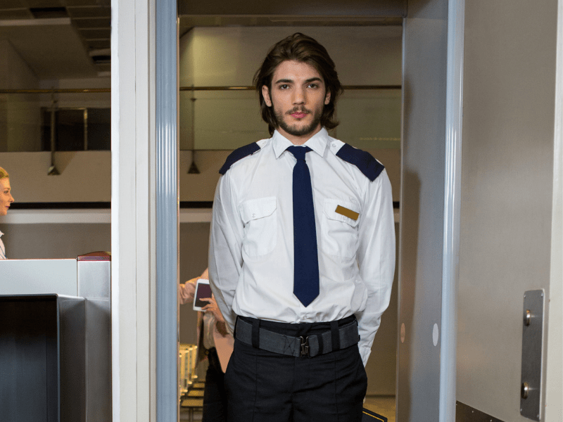 A TSA officer waiting for the passenger for security check.