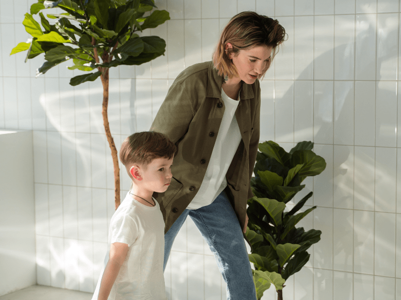 Mother holding hands of her son while walking.