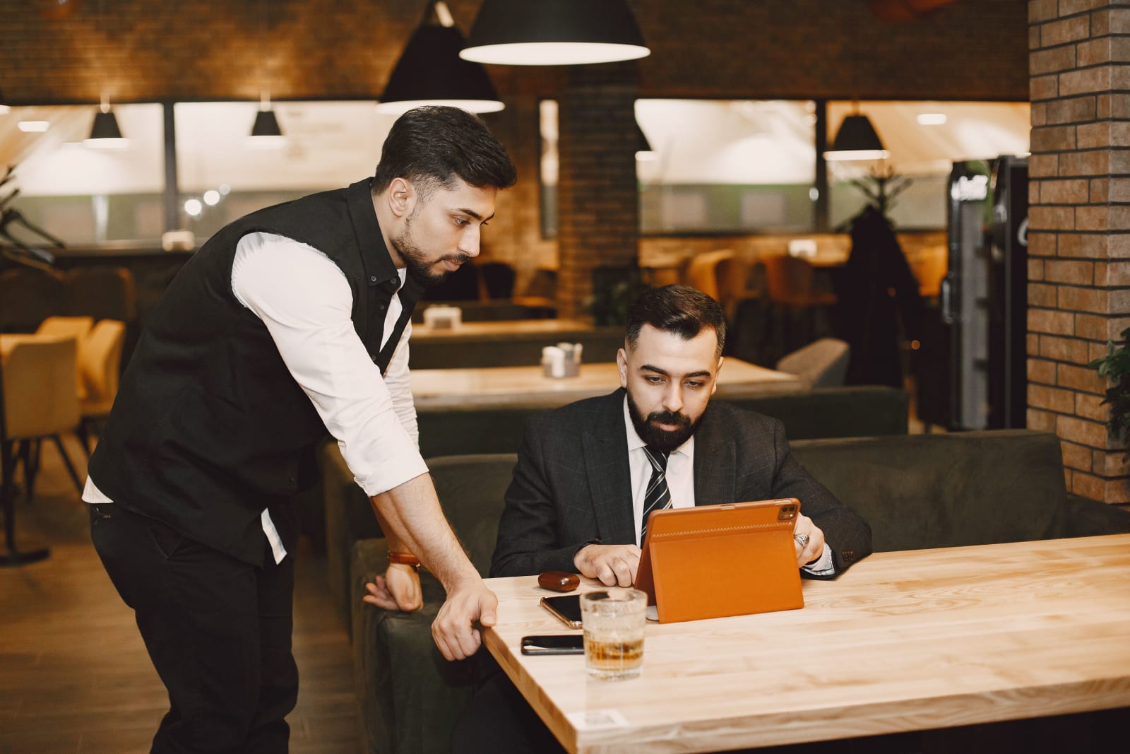 A restaurant staff and a manager browsing something on iPad.