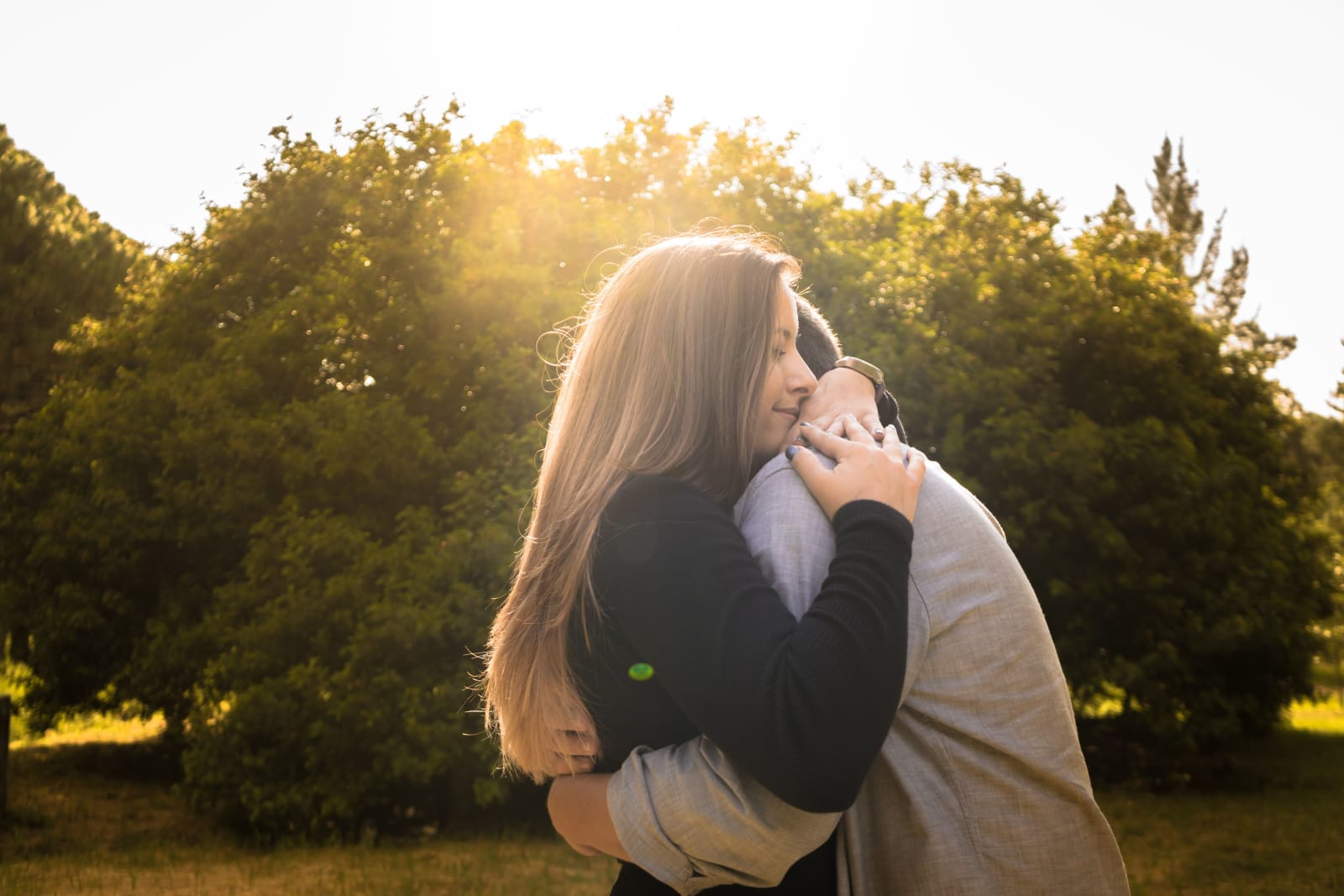 A man and a woman sharing a warm hug.