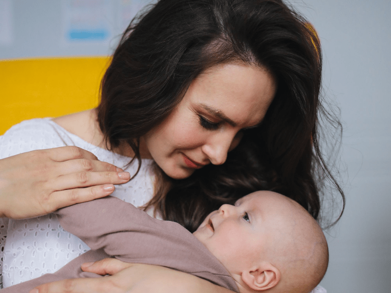 Mother holding her baby looking concerned.