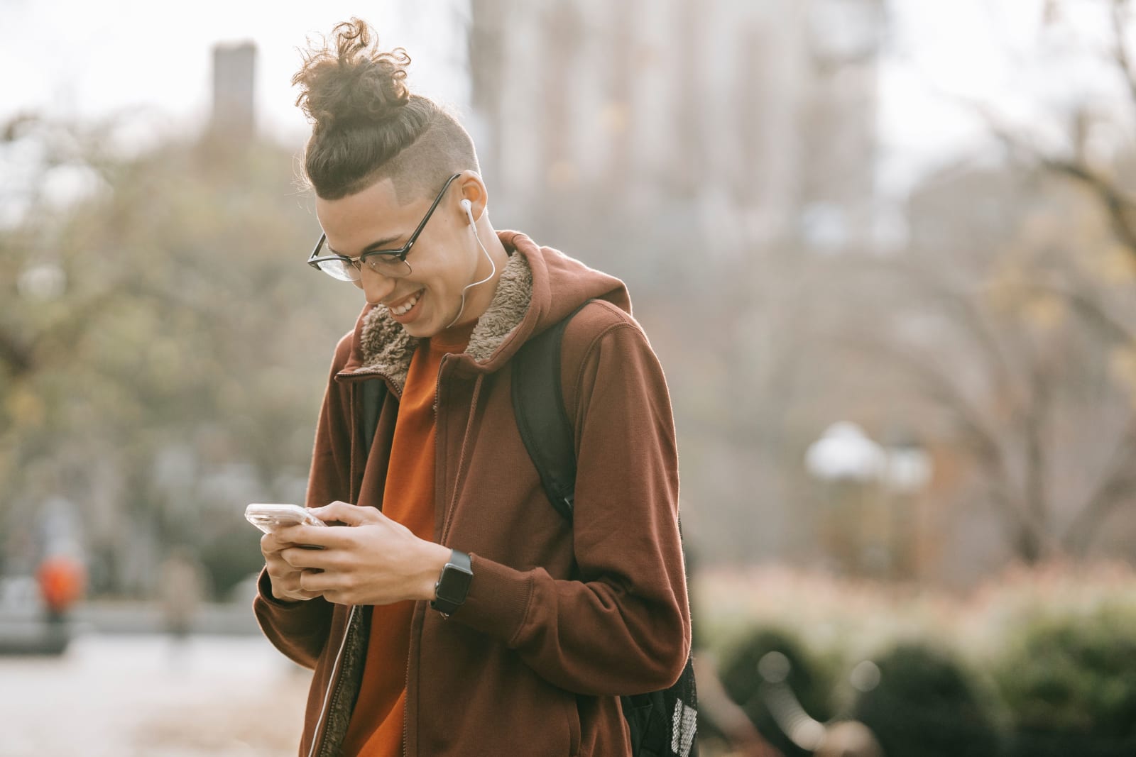 Young man with earbuds using smartphone (Representative Image Source: Pexels | Keira Burton)