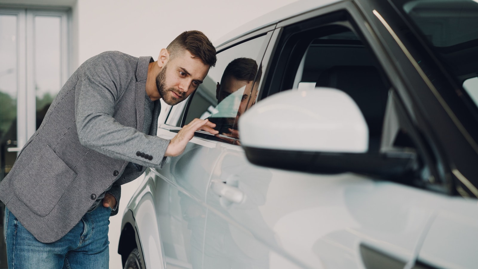 Man checking dust on his car.