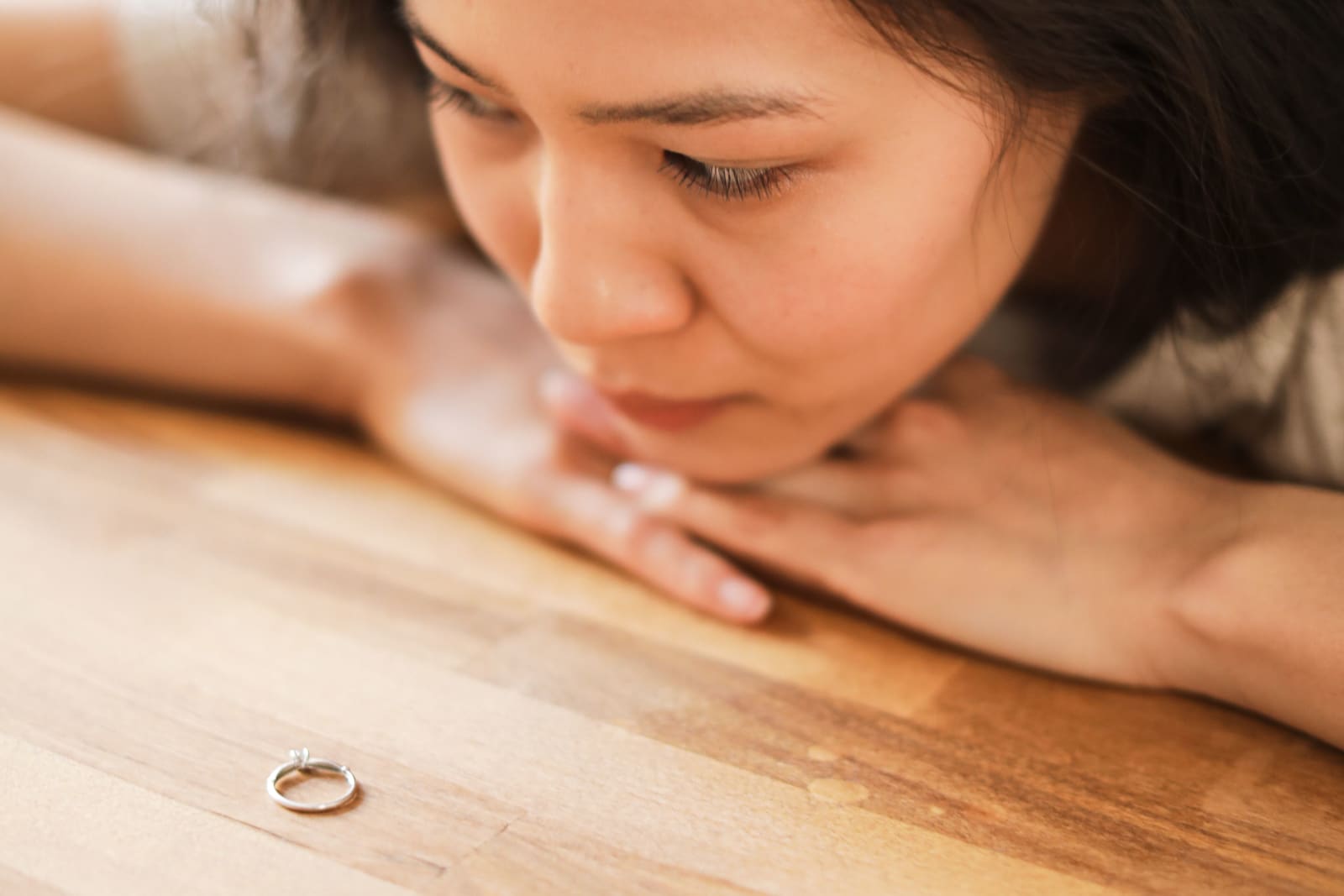 A woman looks at her wedding ring, pondering her relationship. (Representative Image Source: Pexels| Ron Lach)